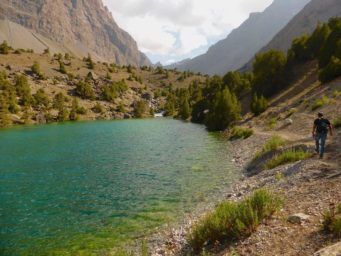 Tourist trekking in the Fann mountains near lake in Tajikistan travel guide