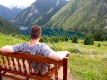 Tourist looking from the bench at Kolsay Lake kazakhstan travel