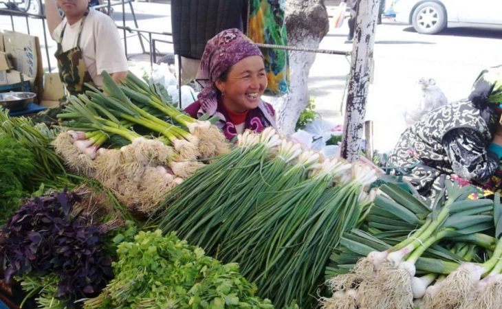 lady selling fresh herbs in bazaar during Kyrgyzstan travel