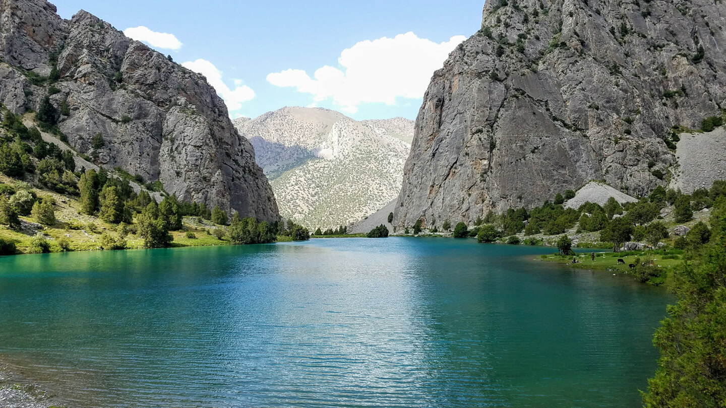 Chukurak lake surrounded by grey cliffs in Tajikistan